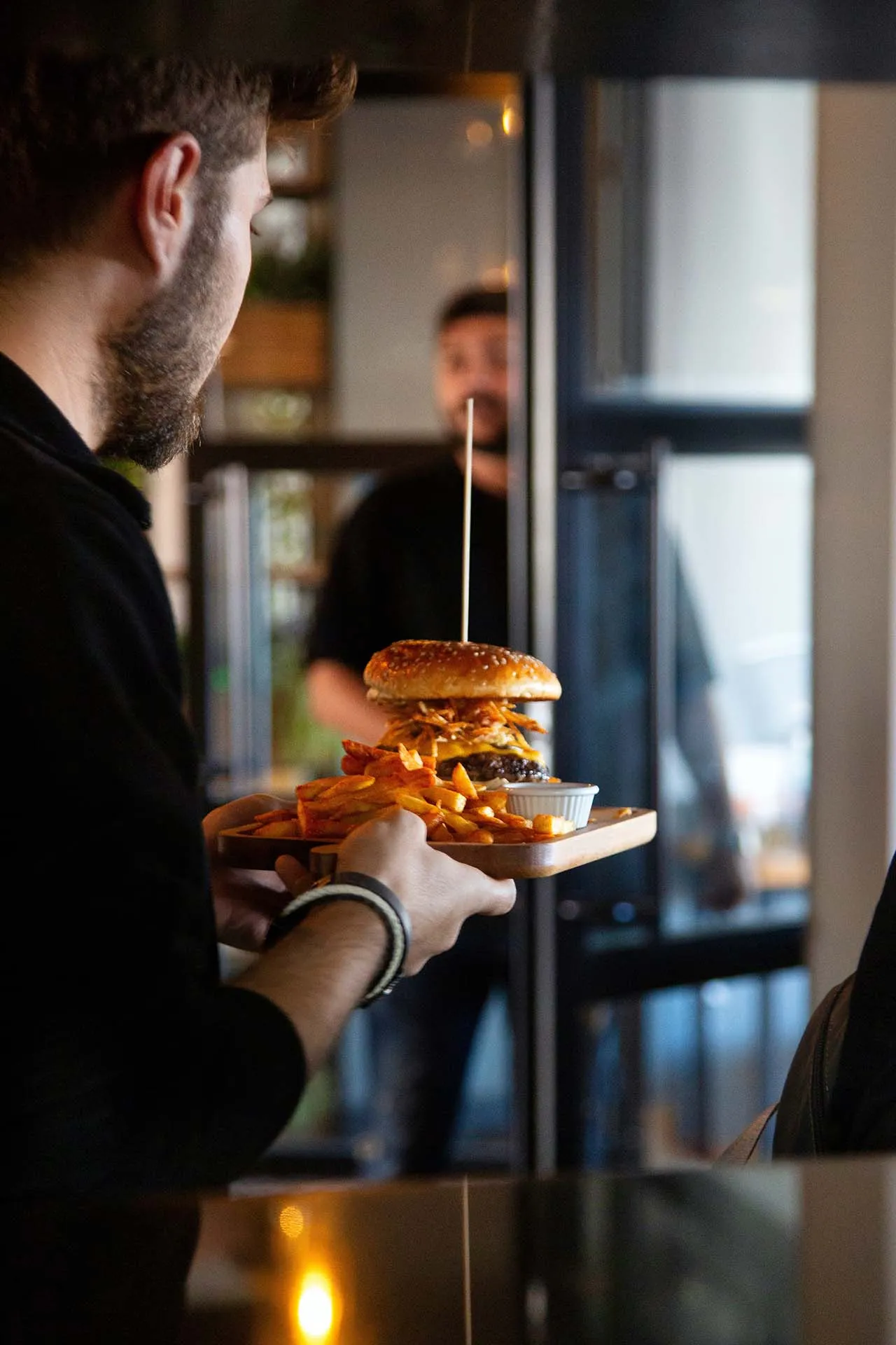 Persona llevando una hamburguesa.