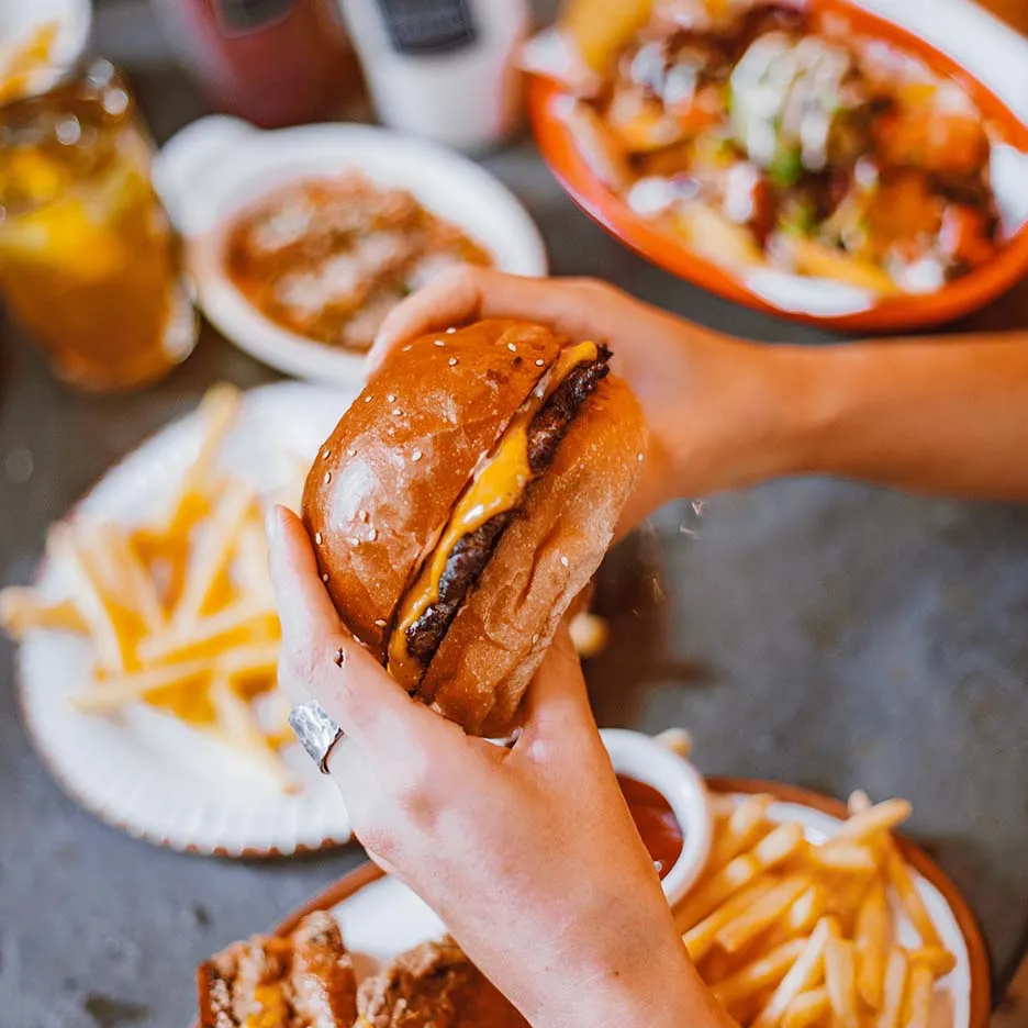 Persona a punto de comer una hamburguesa.